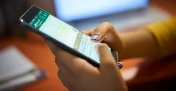 Business owner sending a WhatsApp message with a Google review link to a customer